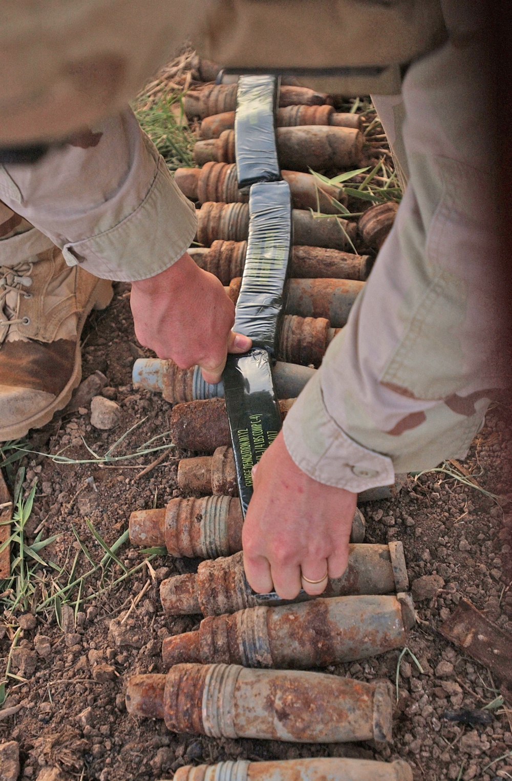 A soldier lays down C4 to destroy unexploded ordnances