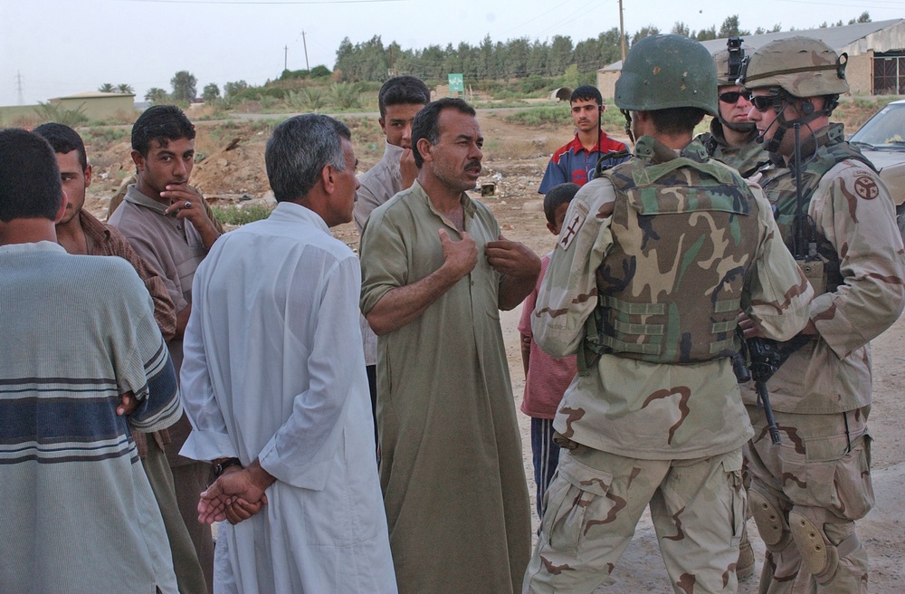 SSG Brian M. VanNote talks with Iraqis during a stop