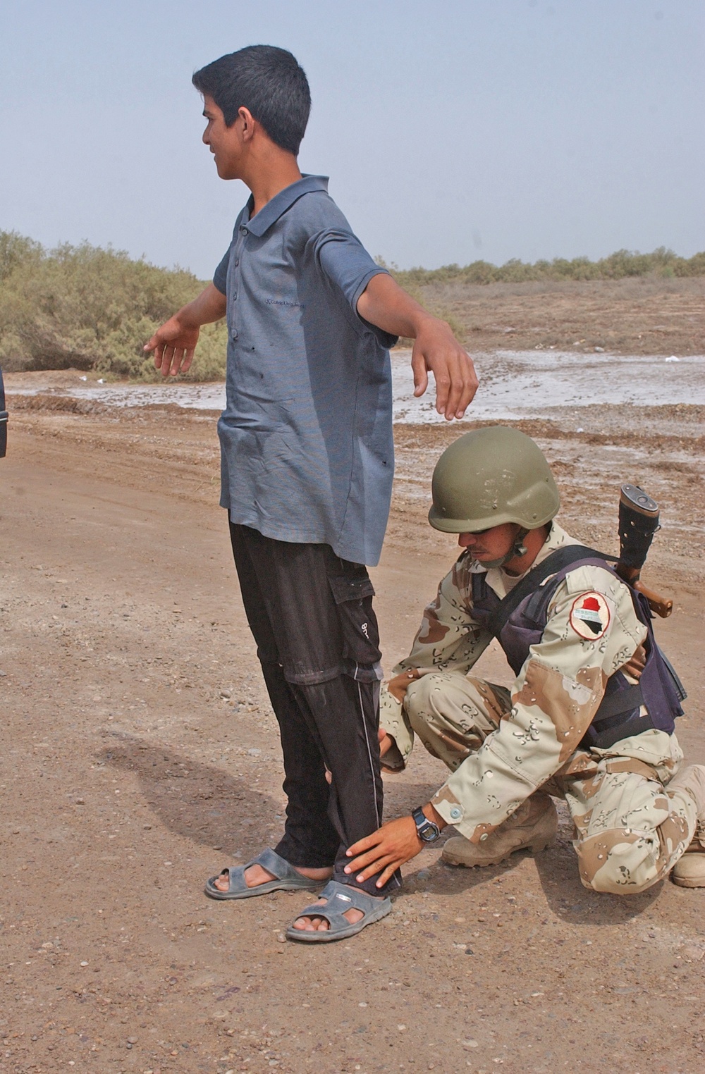 A Soldier searches an Iraqi Civilian at a traffic control point