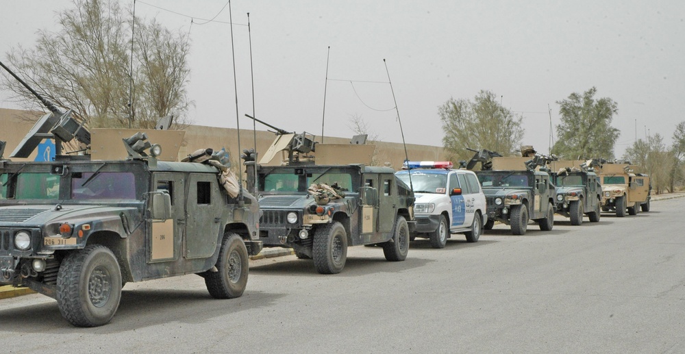 An Iraqi Highway Patrol Vehicle sits between the Humvees