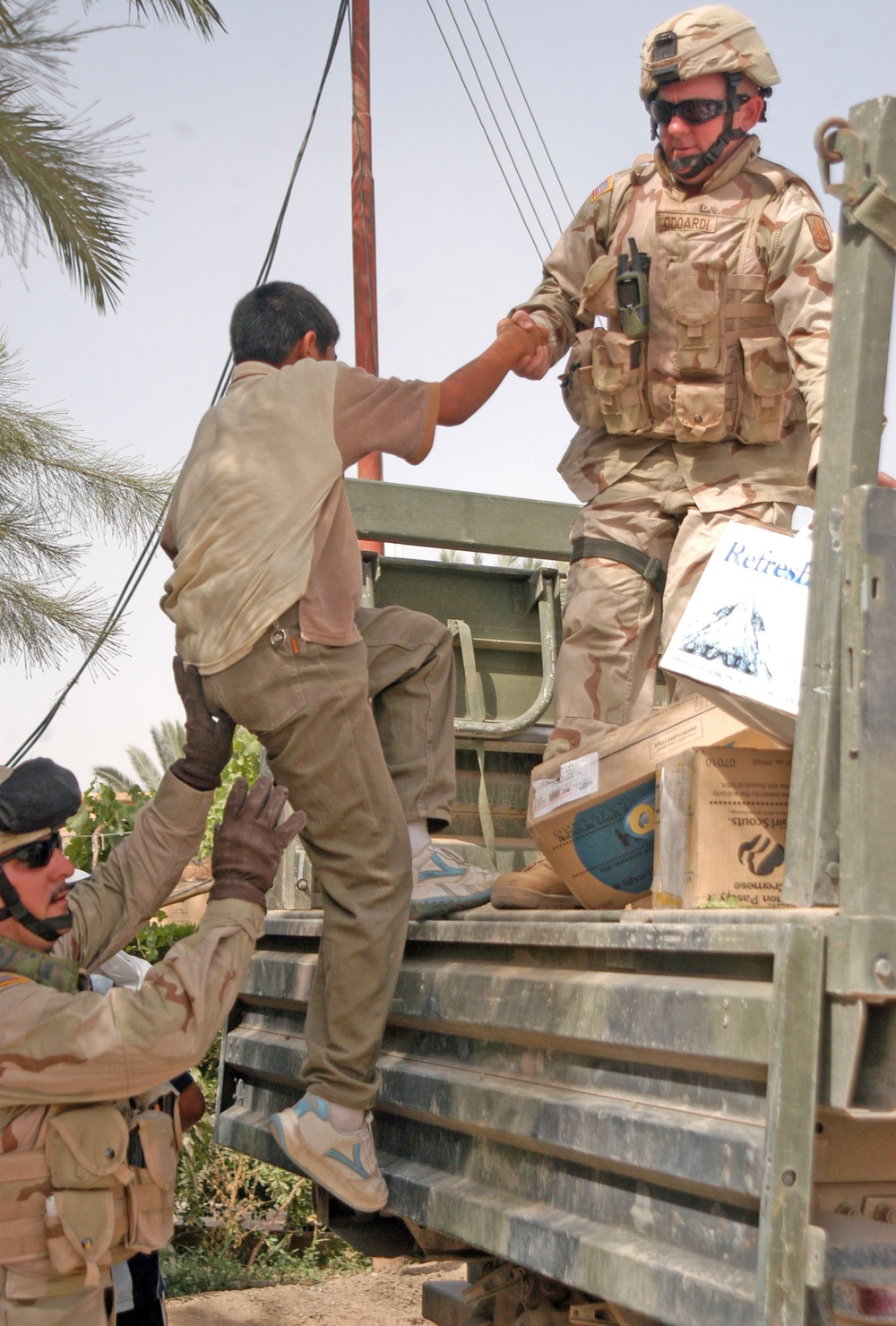 15-year-old David, an Iraqi boy, is helped into the LMTV