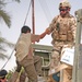 15-year-old David, an Iraqi boy, is helped into the LMTV