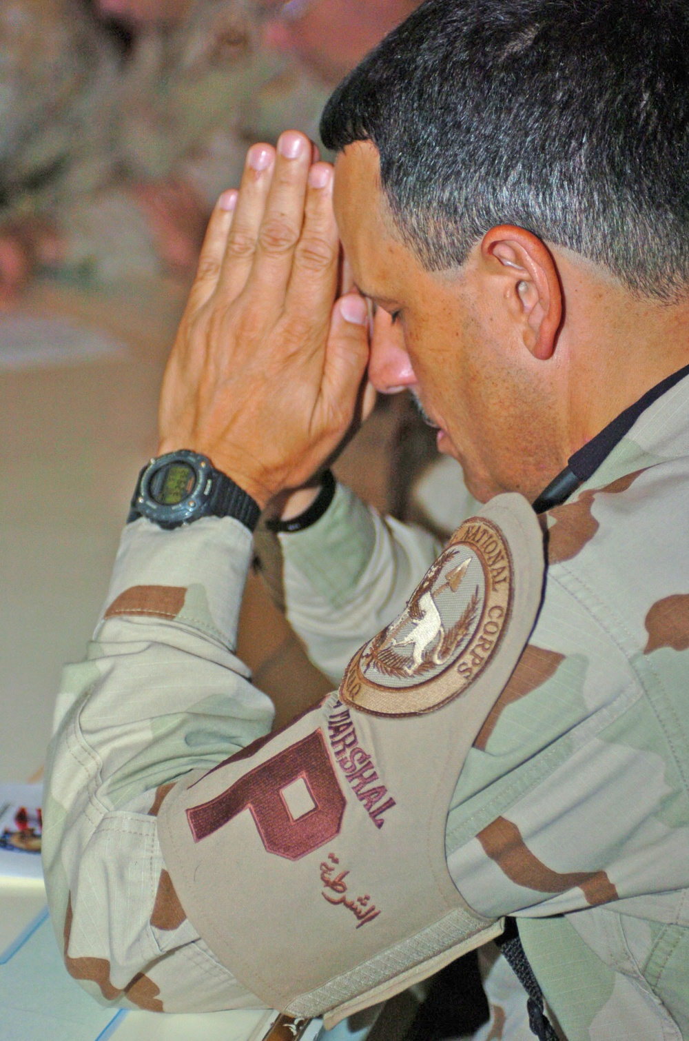 Col. Arnaldo Claudio bows his head during the benediction