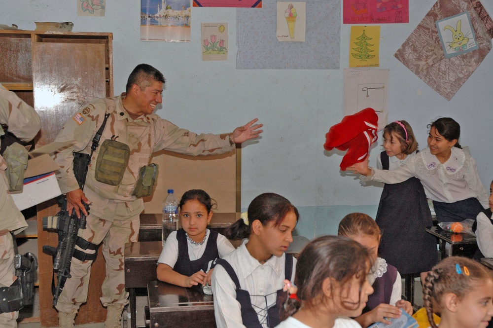 Lt. Col. Garcia tosses a t-shirt to an Iraqi children