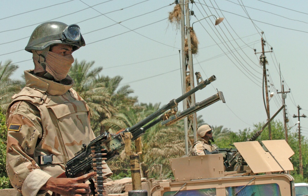A Soldier secure a cordon area alongside American troops