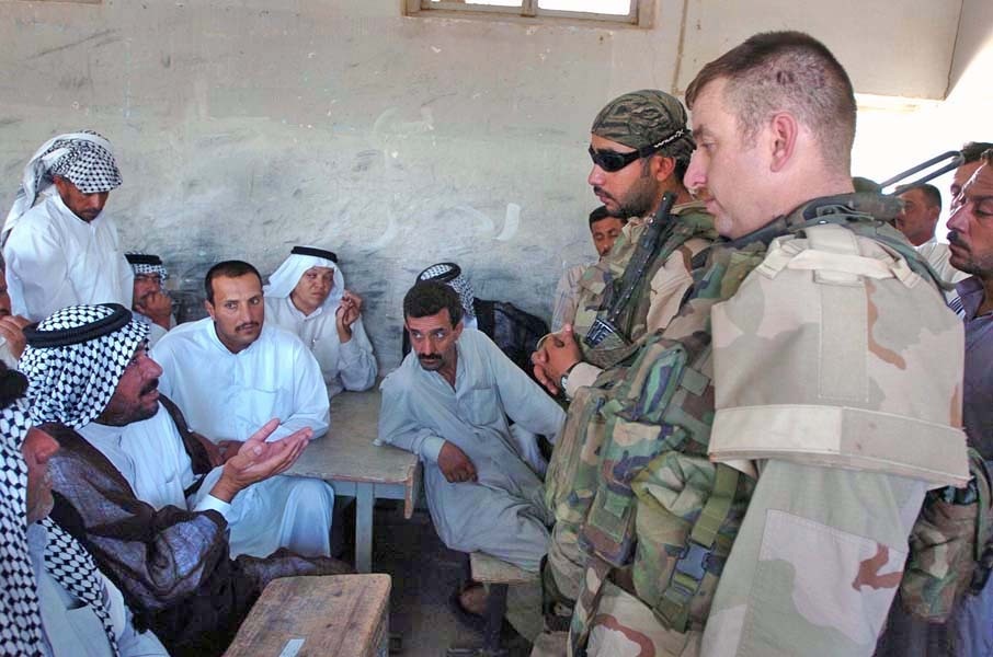 Capt. Brett Bair peaks with residents at a school