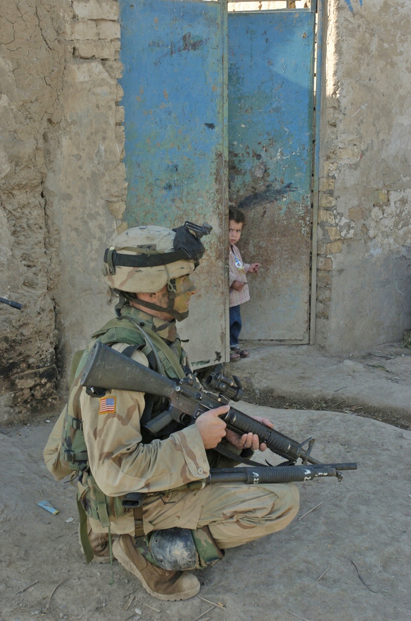 A soldier watches the crowd of Iraqi civilians
