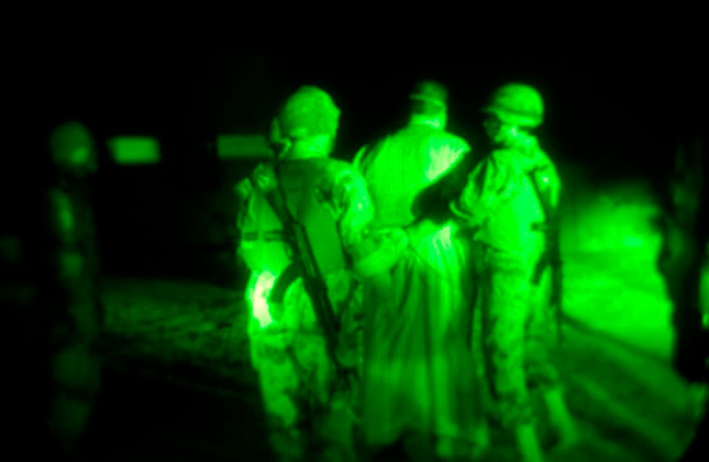 Two soldiers escort a detainee to the holding Two soldiers escort a detainee to the holding