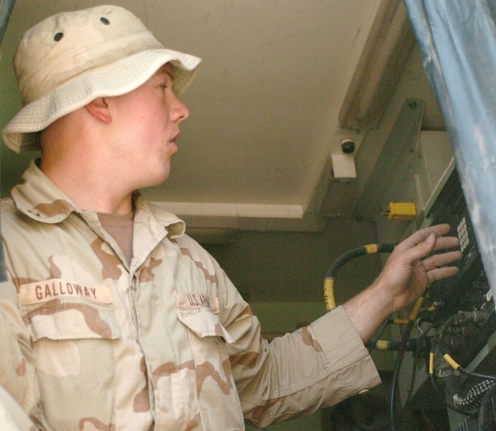 Pfc. Bryan Galloway adjusts a radio system