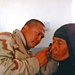 Cpt. Roy Duano checks a woman ears during their mission