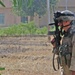 A Soldier patrols a field after an air assualt raid