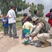 SFC Gary DeLorme give a Iraqi girls a pair of shoes