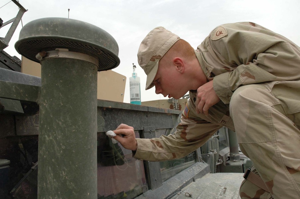 Spc. Rodney R. Foster cleans off his Humvee windshield