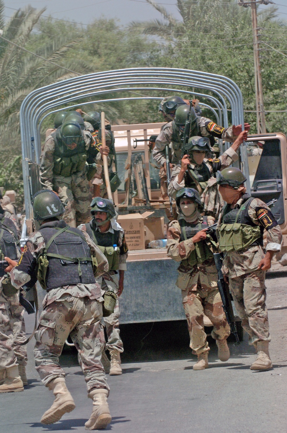 Iraqi Army jump out of a truck to search a house