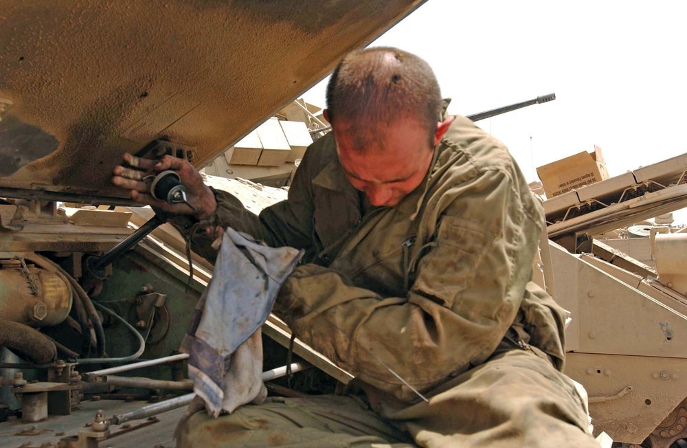 Spc. Seals checks the engine oil on an M2 Bradley