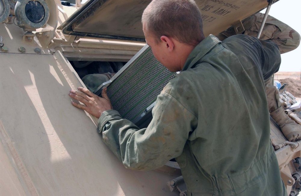 Pfc. Zachary Watson checks the air filter on a M1064