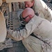 Soldiers insert a pin in the track on an M2 Bradley