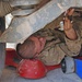 Pvt. Weston tightens a bolt underneath a Humvee