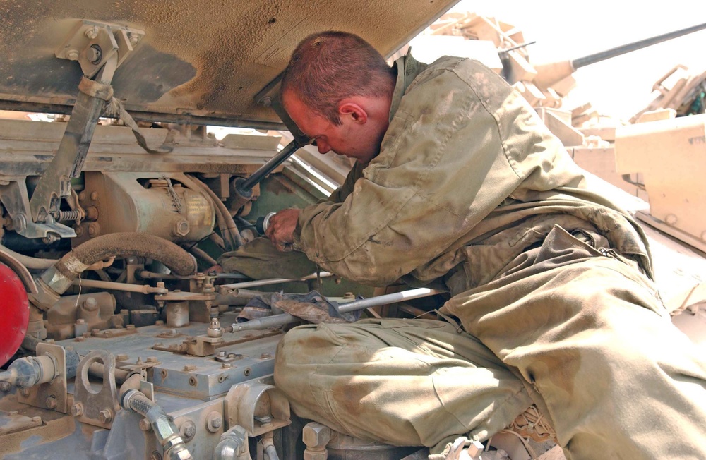 Spc. Seals checks the engine oil on an M2 Bradley