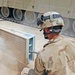 A soldier uses an air wand to remove the dirt from the tank's V-