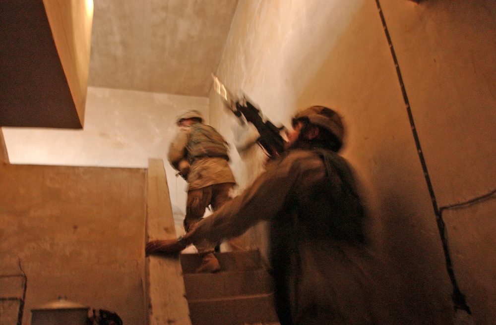 Scouts check the roof of a house during a raid