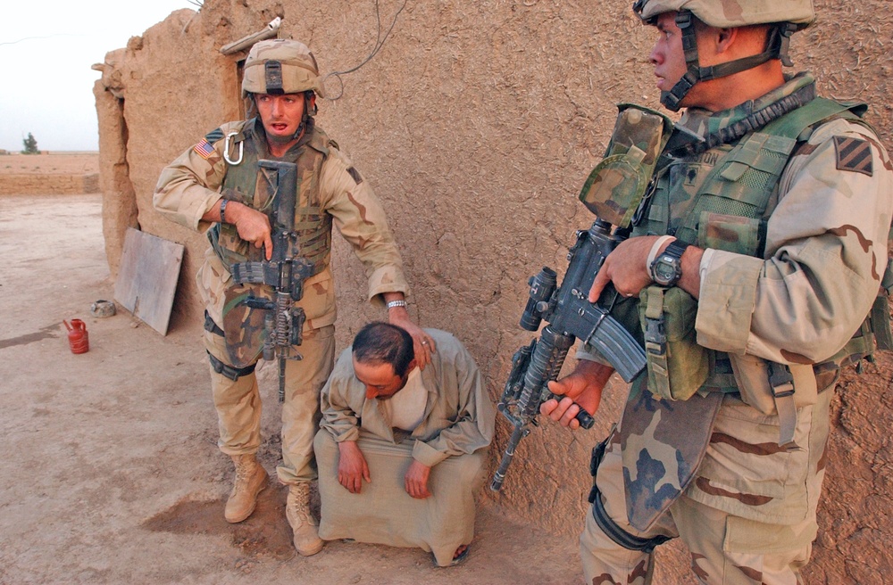 SSgt. Cardinal holds a man who will be questioned