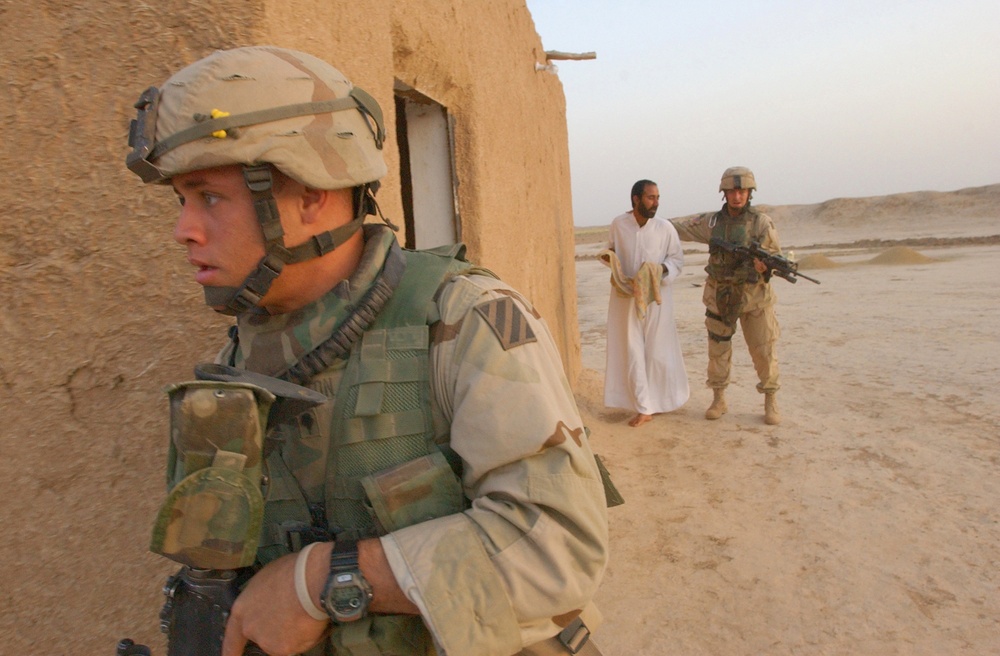 Spc. Winston moves around the corner of a building