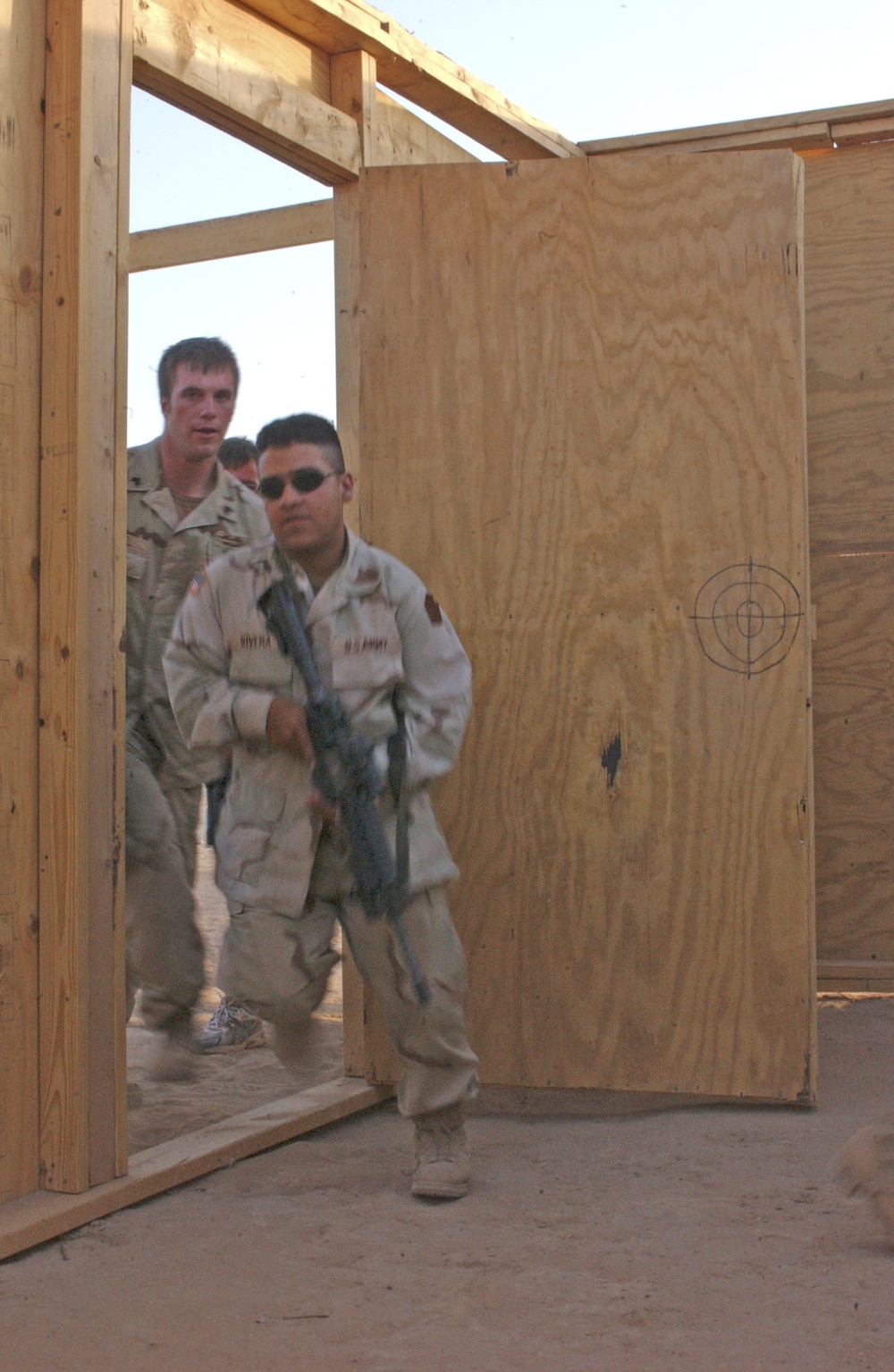 Soldiers practices entering the door of a mock home
