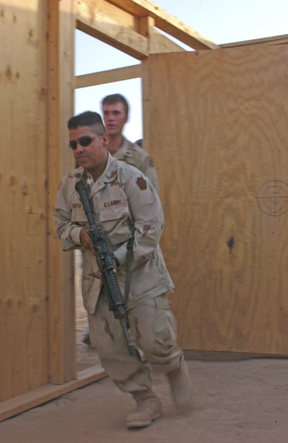 Soldiers practices entering the door of a mock home
