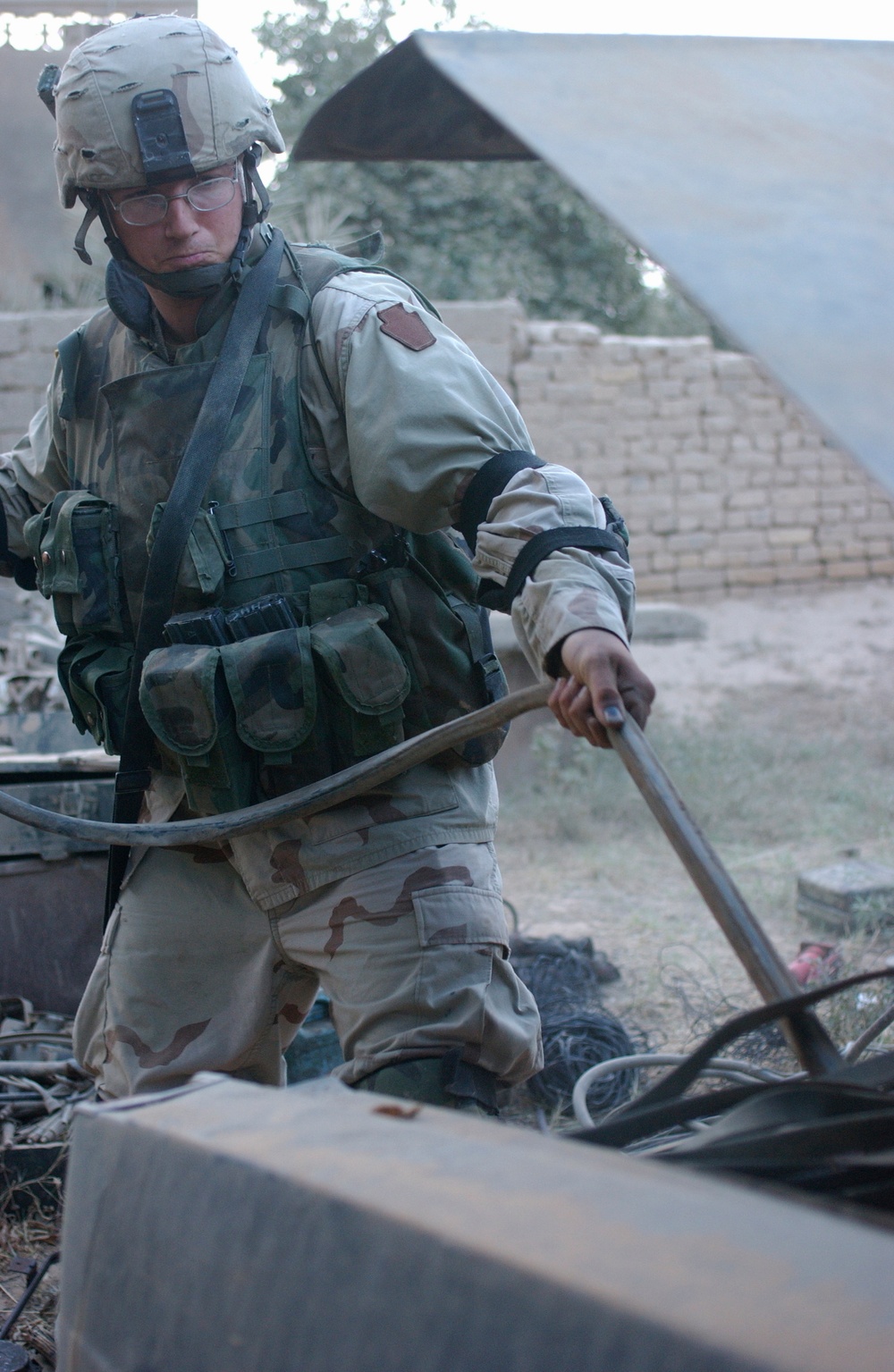 Spc. Ryan Kocher pulls electrical wires out of a vehicle