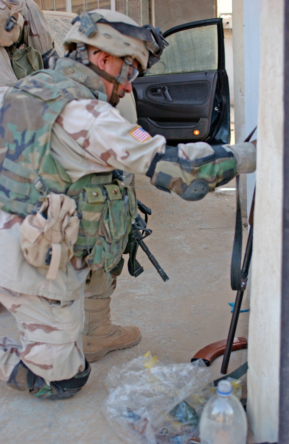 A Soldier examines an AK 47 found during a raid