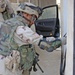 A Soldier examines an AK 47 found during a raid