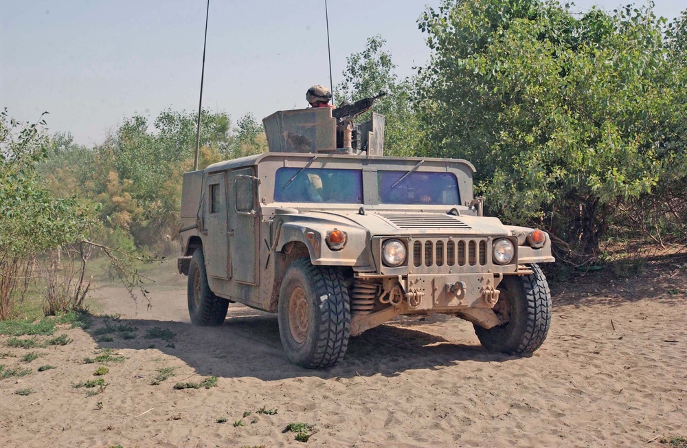 A Humvee drives out of a trail