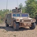 A Humvee drives out of a trail