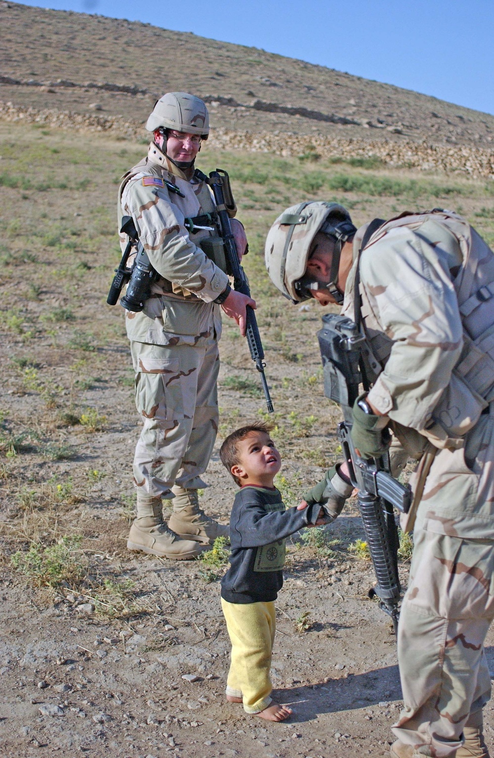 A Soldier shakes the hand of an Iraqi boy