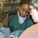 SPC Jordan and MAJ Anne Mitzak prepare a child
