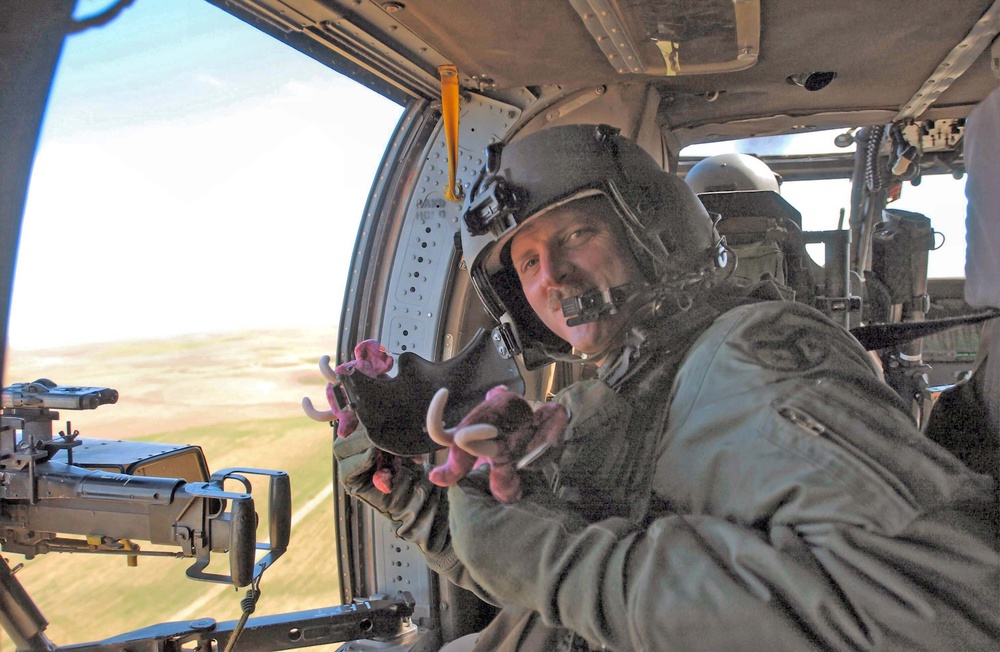 Helicopter crew member tosses stuffed toys
