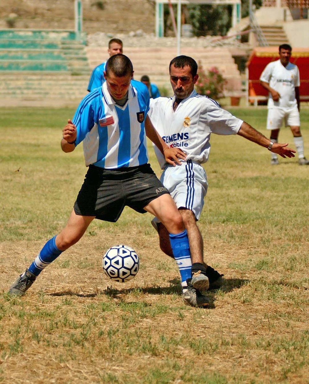 Iraqi and US Soldiers have a friendly game of soccer.