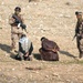 Two Iraqi Army Soldiers stand watch ver two detained men