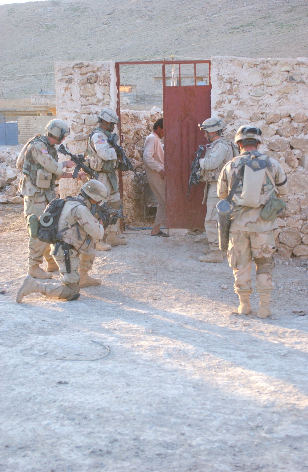 3rd ACR Soldiers outside the doorway of an Iraqi citizen's household.