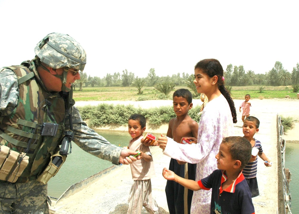 MAJ Cuttle shares candy and smiles with Iraqi children
