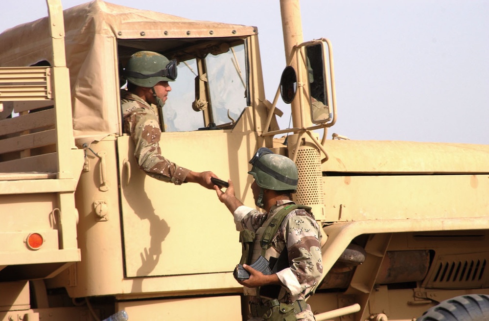 The passenger of a 2nd MTR truck receives a new magazine of AK-47 ammunitio