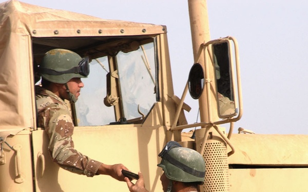 The passenger of a 2nd MTR truck receives a new magazine of AK-47 ammunitio