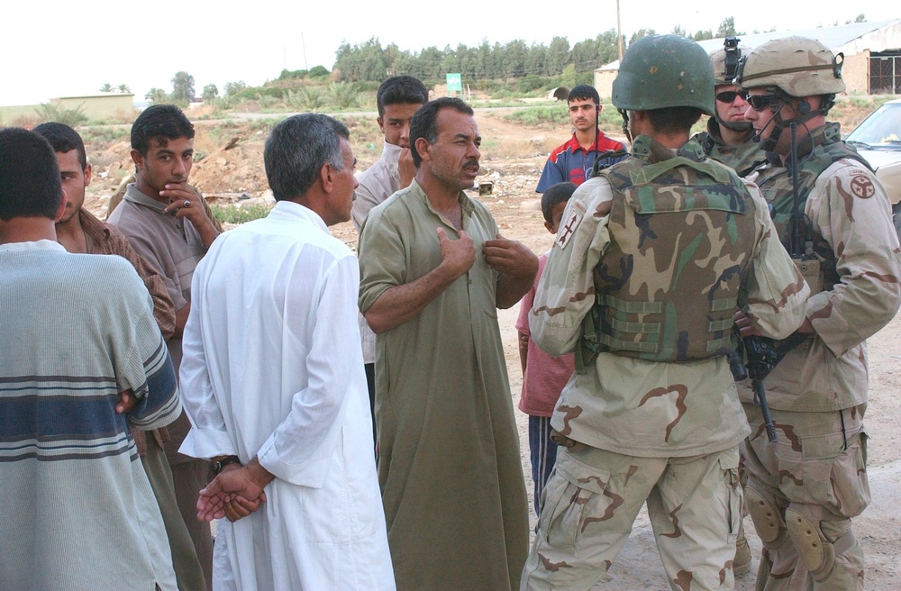 SSG Van Note talks with Iraqis during a stop on a combat patrol near Balad