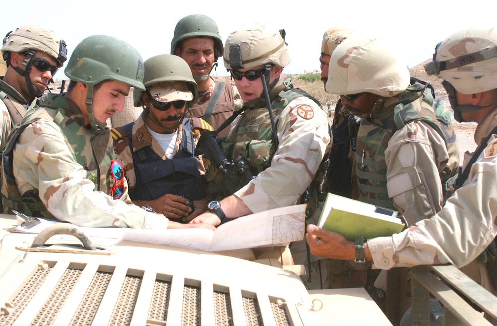 SSG Van Note briefs a squad leader during a stop on a combat patrol near Ba
