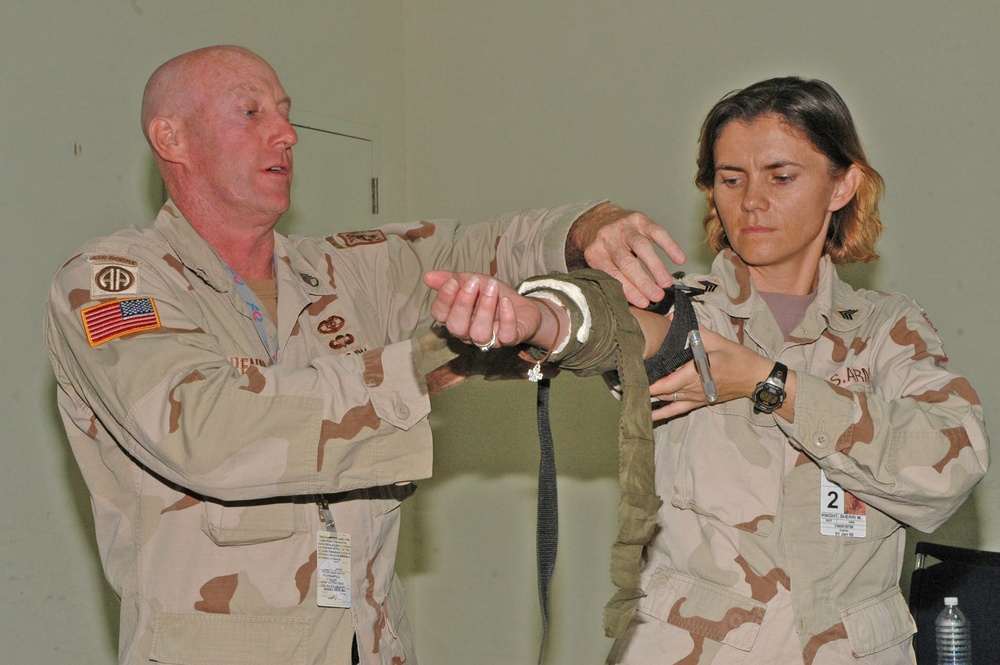 Staff Sgt. Thomas J. Brennan applies a tourniquet