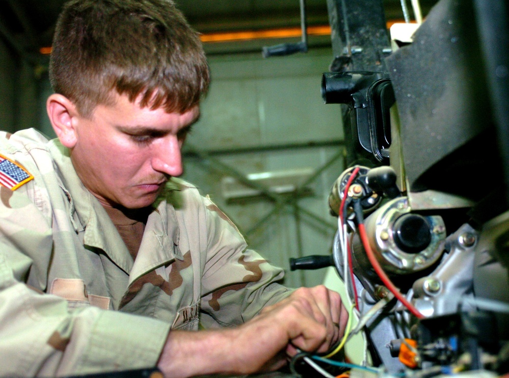 Pvt. Josh B. Dennis repairs