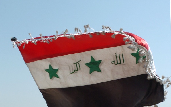 A female IP officer waves the Iraqi flag
