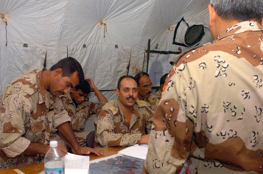 An Iraqi captain briefs an Iraqi major during a command post exercise
