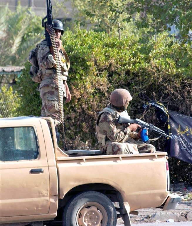 Iraqi Soldiers provide security from a side street during a cordon and sear